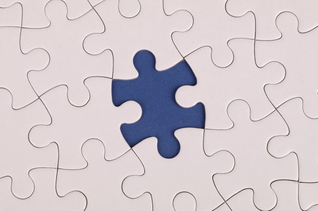 White puzzle on a blue table with one missing piece